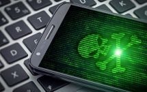 skull of death on smartphone screen. Hacked mobile phone on laptop computer